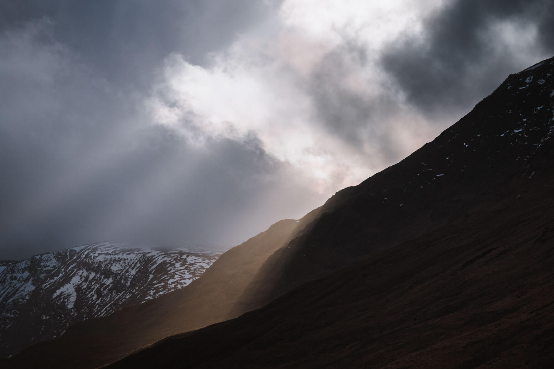 Sun breaking through the clouds over Glen Etive in Scotland