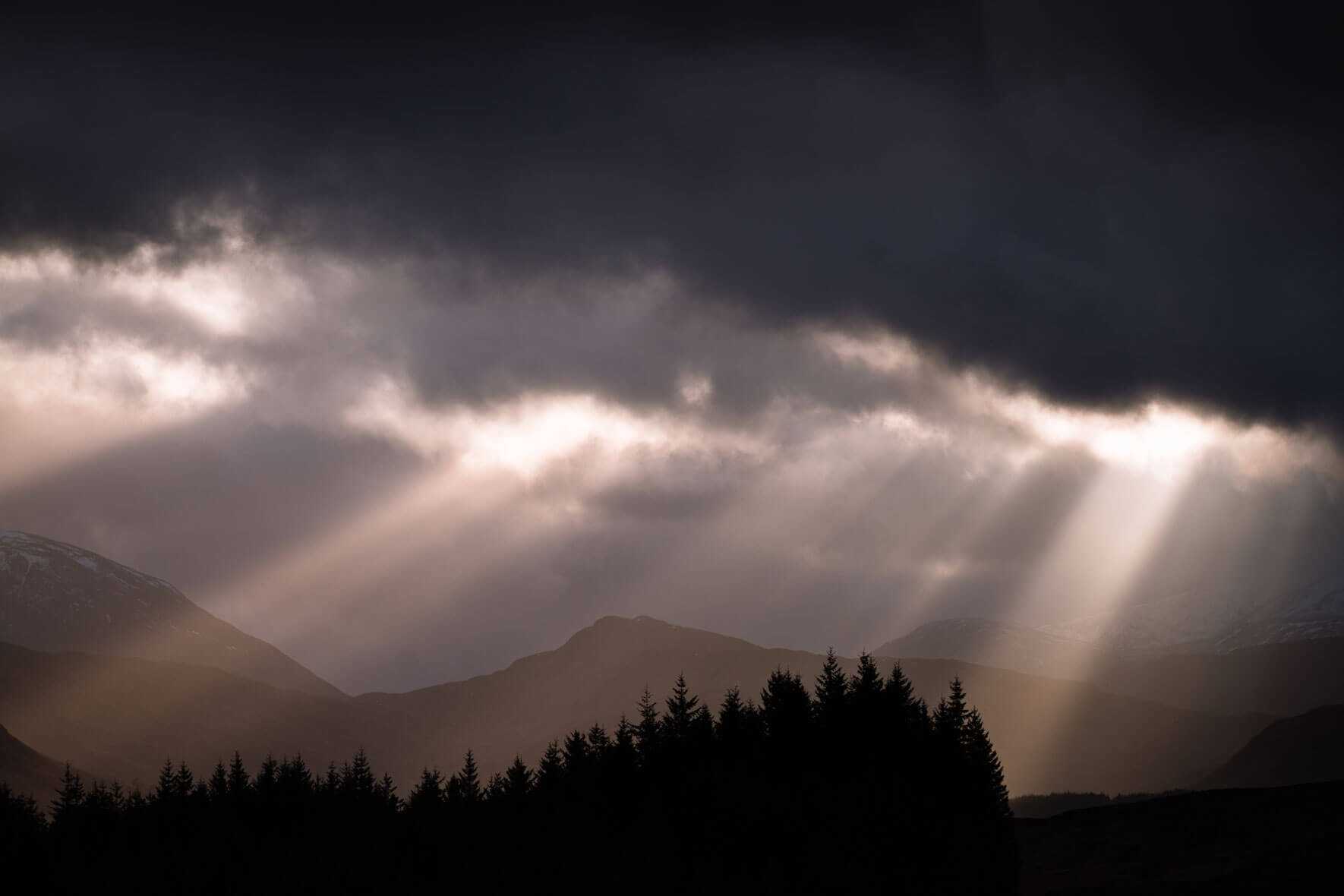 Sun breaking through the dark clouds over Glencoe, Scotland