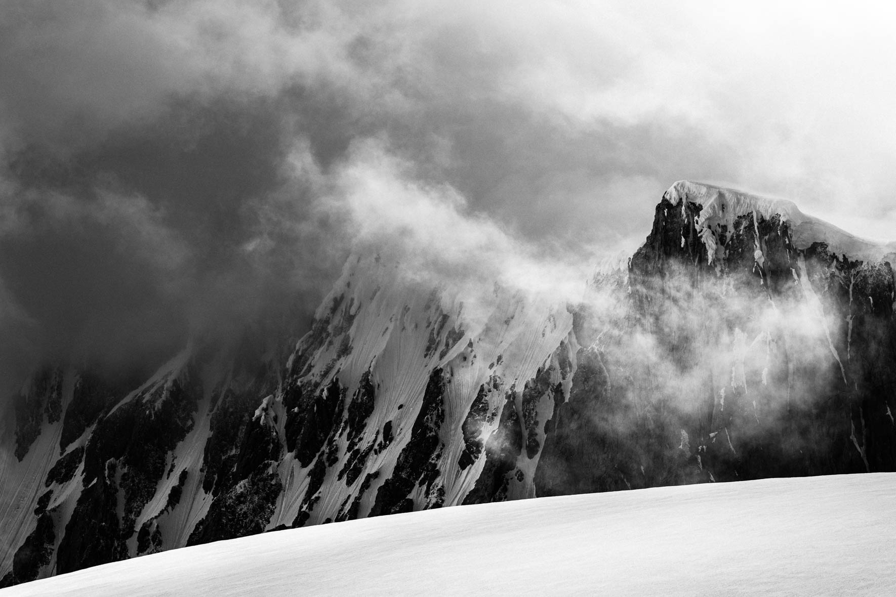 Black and white photo of mountain in the clouds