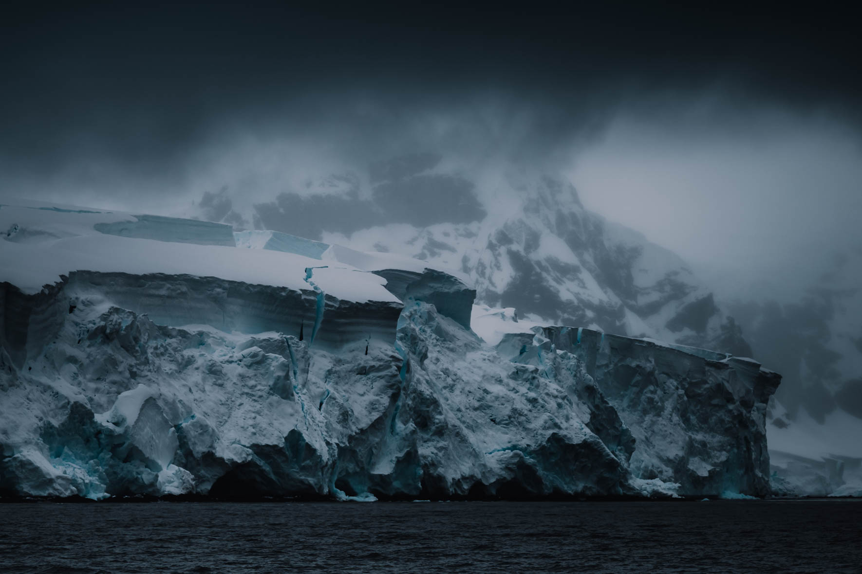 Dark and dramatic landscape of Antarctica with clouds, glaciers and mountains