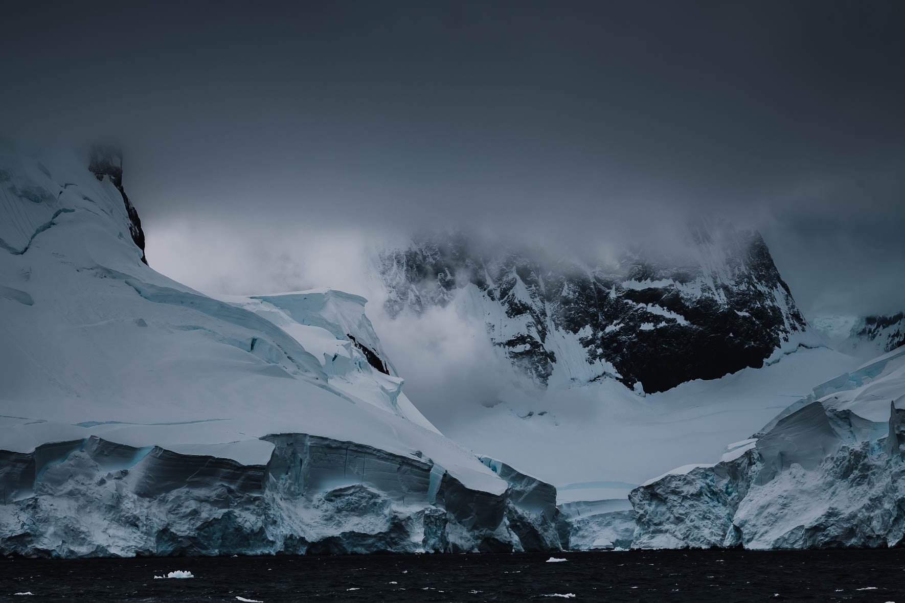 Dark clouds over mountain with glacier in Antarctica