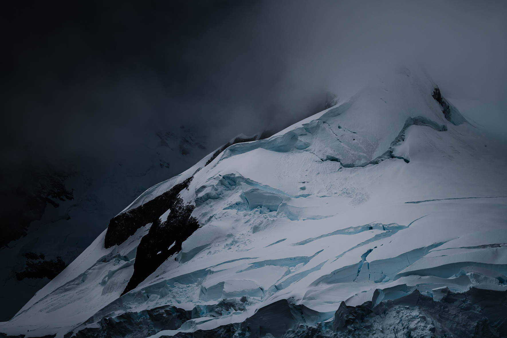 Snowy mountain in Antarctica with dark and moody weather