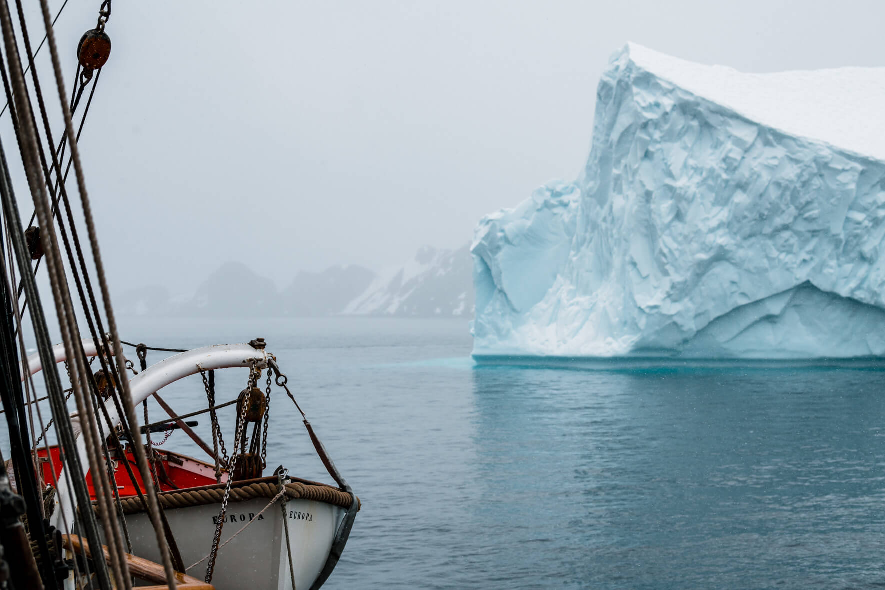 Tall ship Bark Europa with icebergs in Antarctica