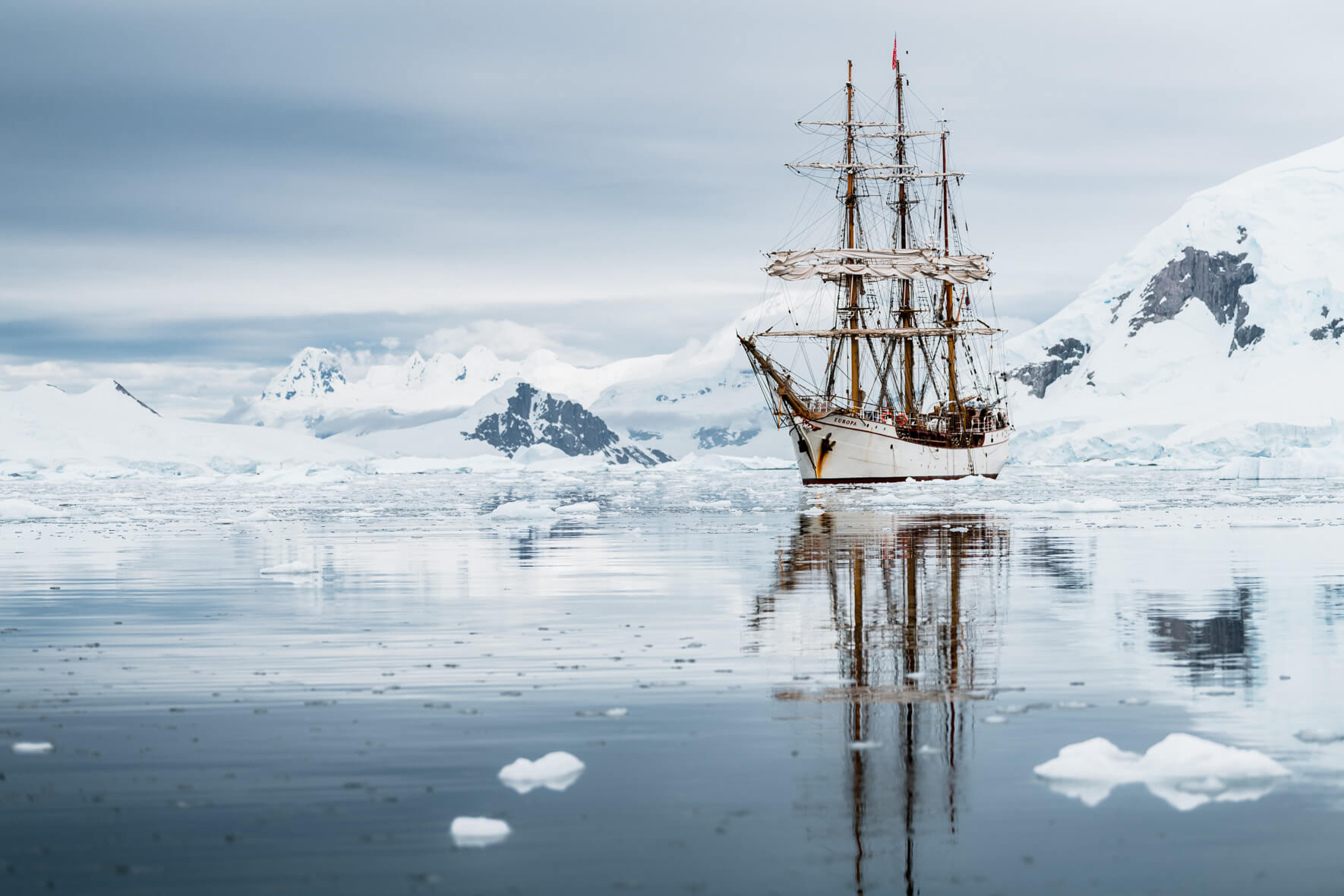 Bark Europa sailing along the coast of the Antarctic Peninsula