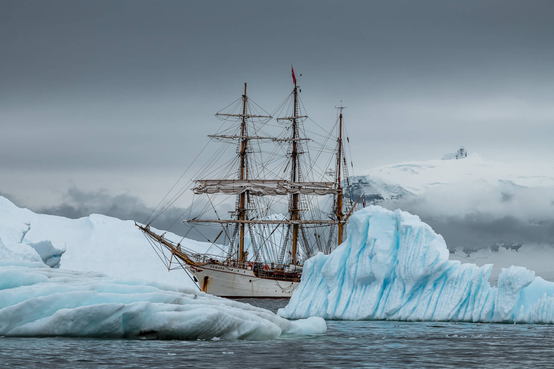 Bark Europa with icebergs along the coast of the Antarctic Peninsula