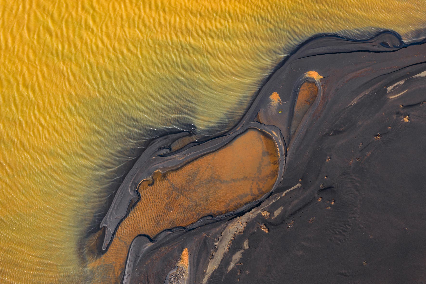 Aerial photograph of abstract lake with dark shoreline in Iceland