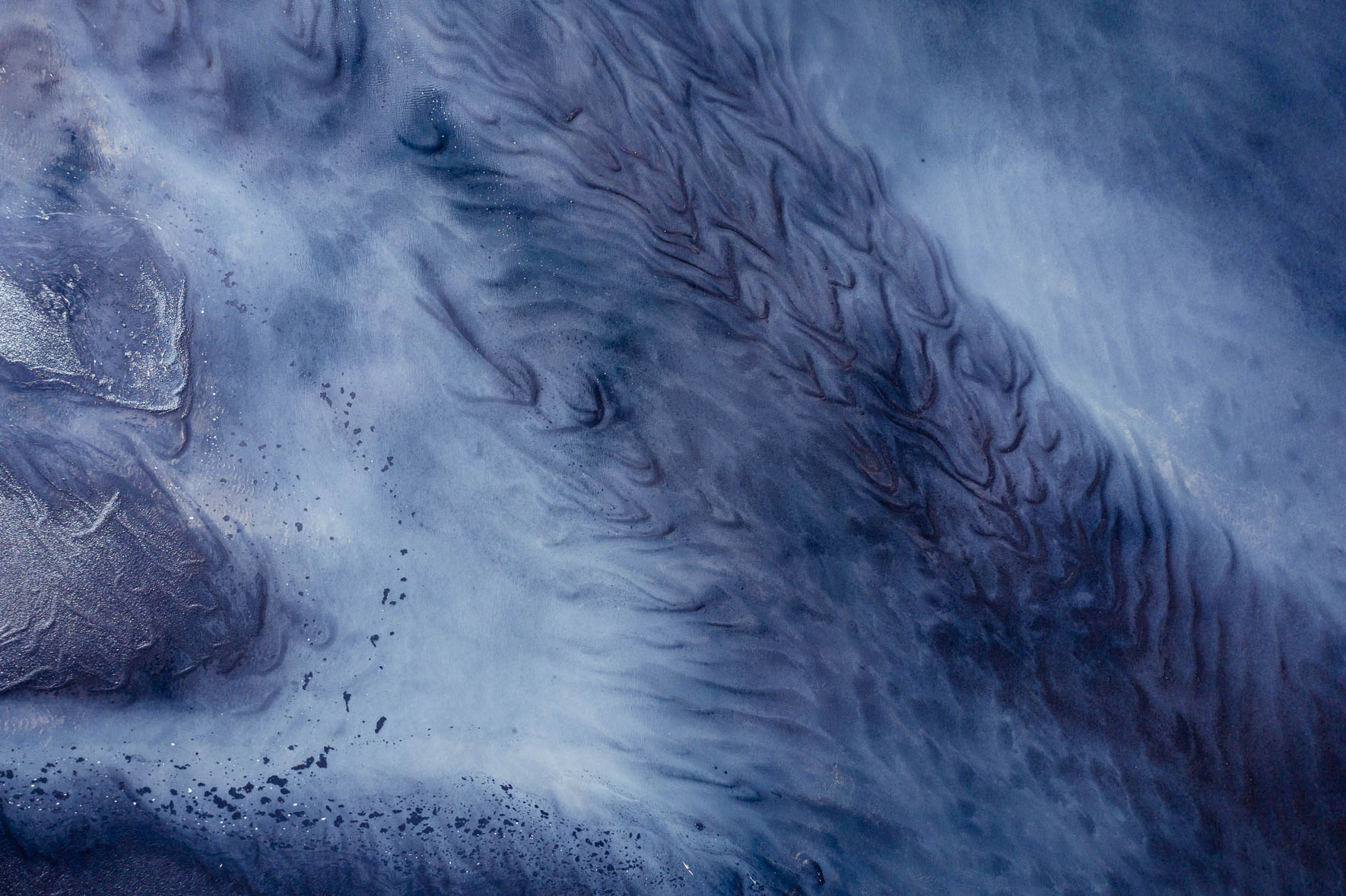 Aerial View of Abstract Tidal Patterns with Black Sand and Sediments