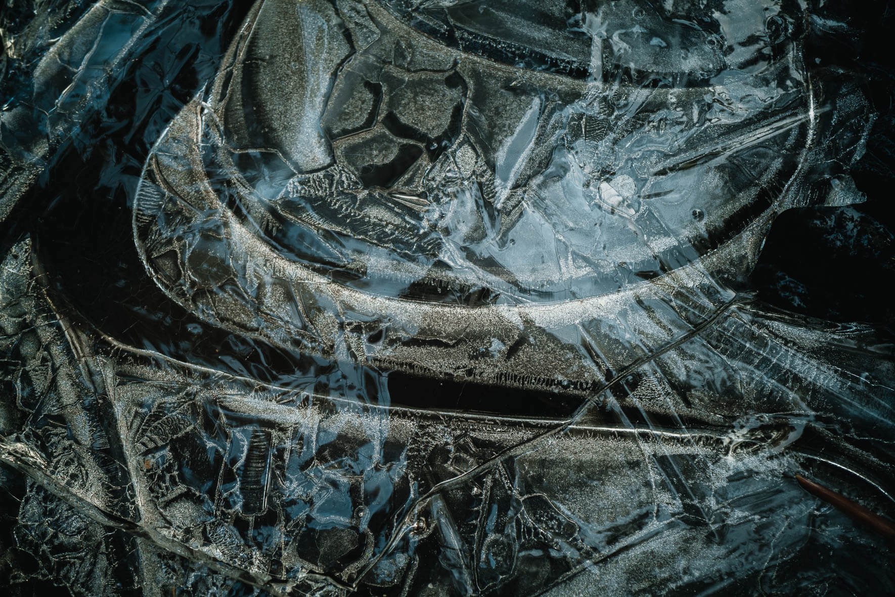Macro photography of frozen puddle with abstract ice structures and light reflections