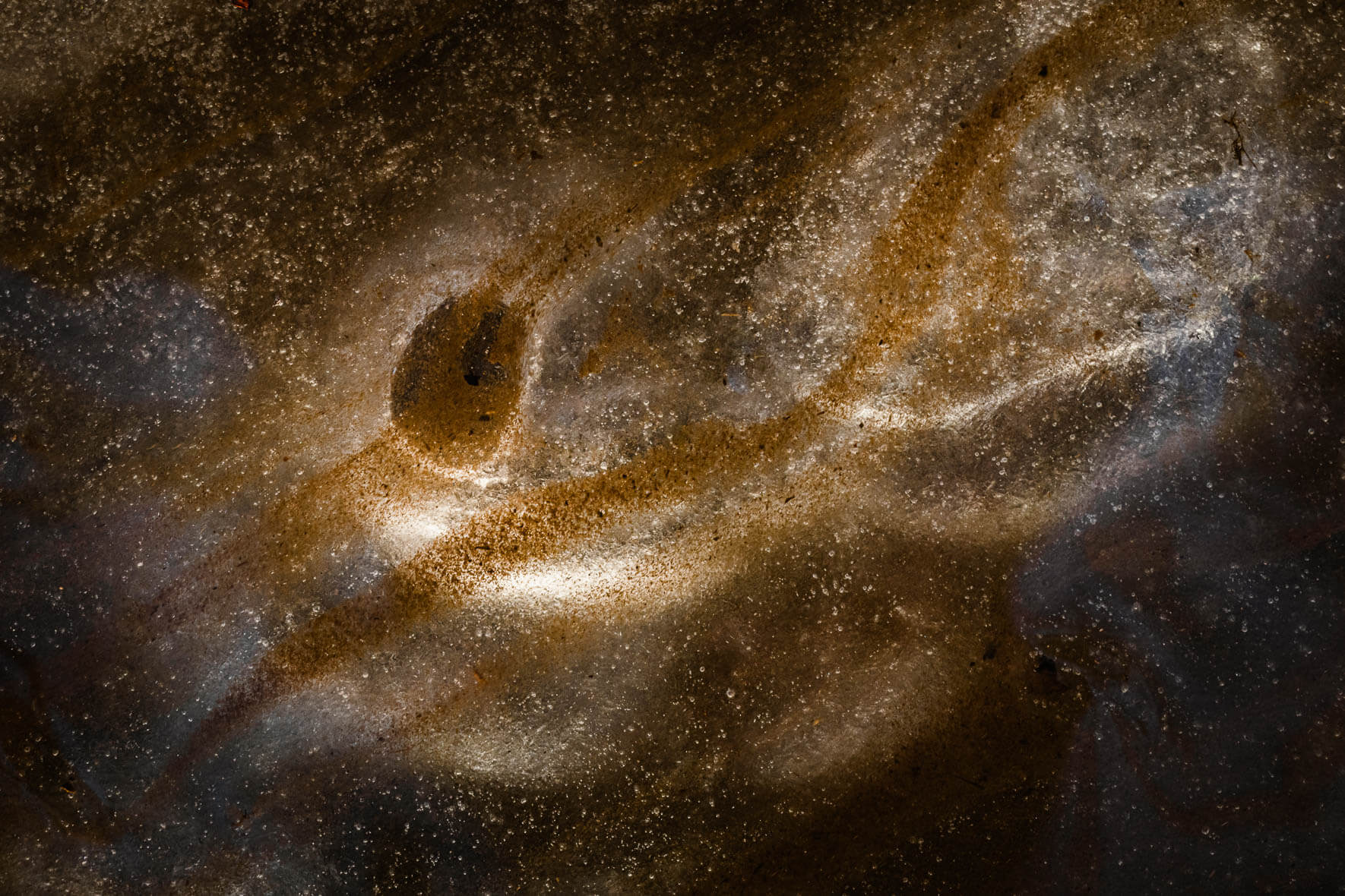 Abstract macro photography of ice with sand structures from a creek