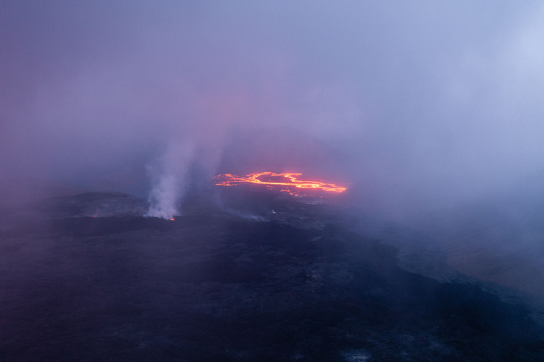 Aerial photograph of flowing lava at the Fagradalsfjall eruption in Iceland covered in steam