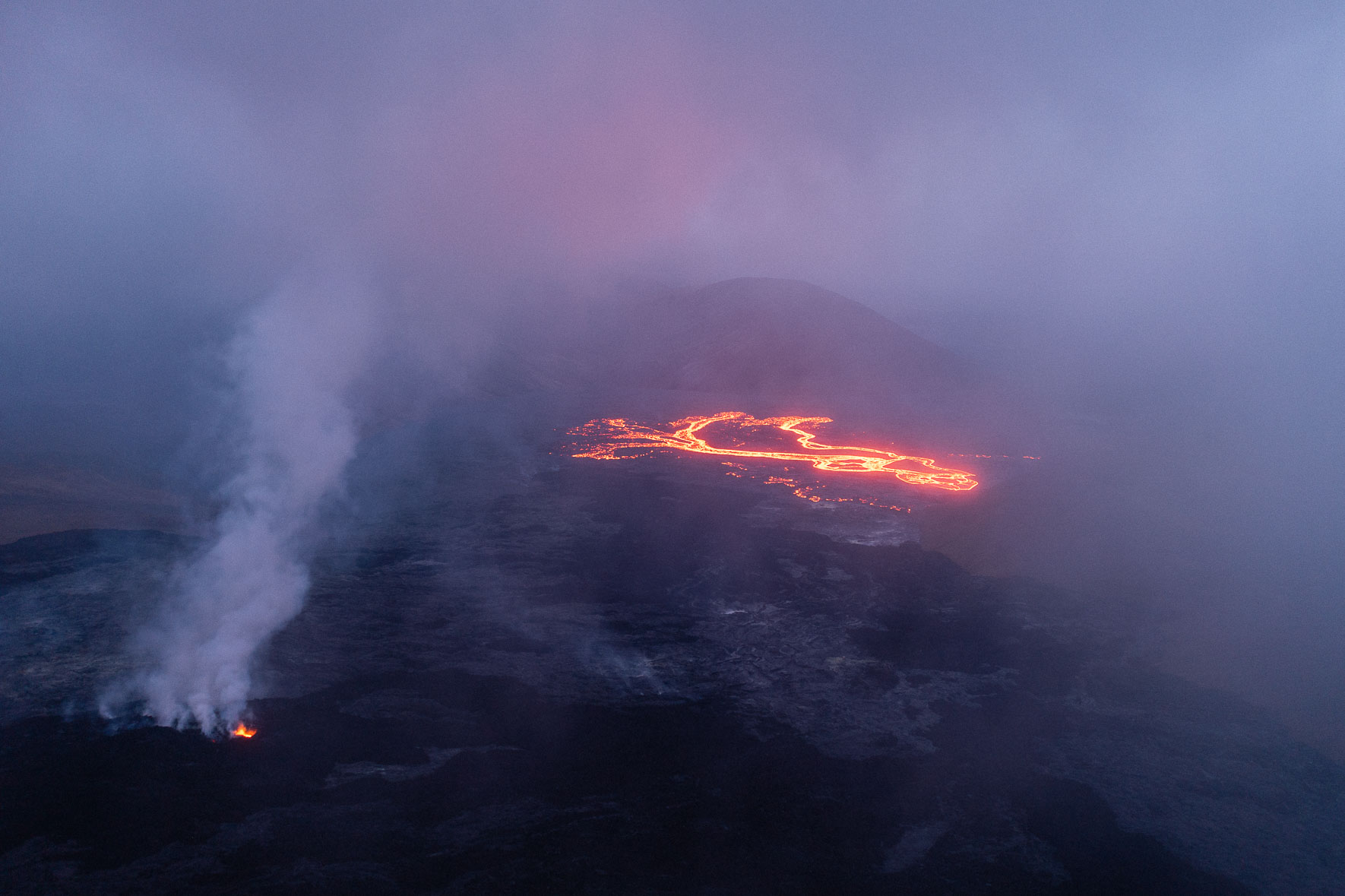 Aerial photograph of a large field of lava at the Fagradalsfjall eruption in Iceland covered in steam
