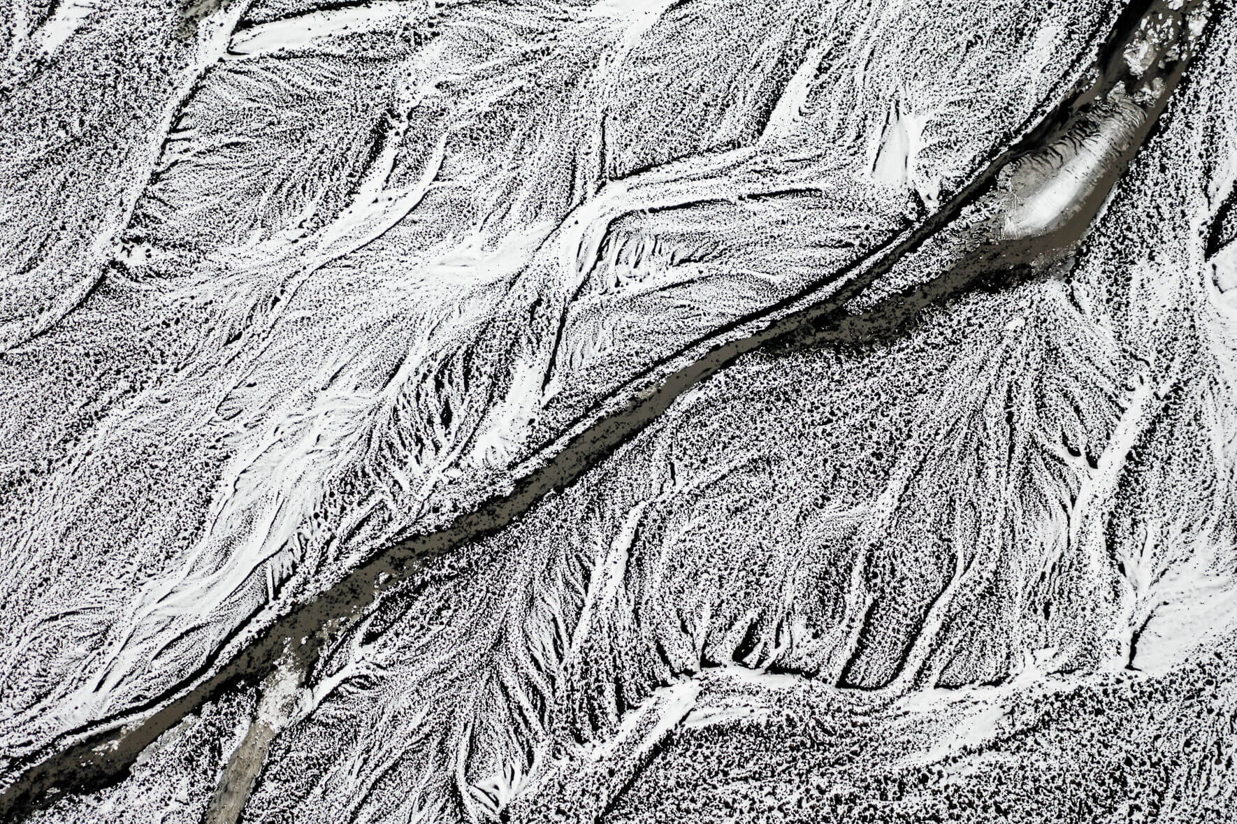 Snow covered sand landscape with small creek and dark water