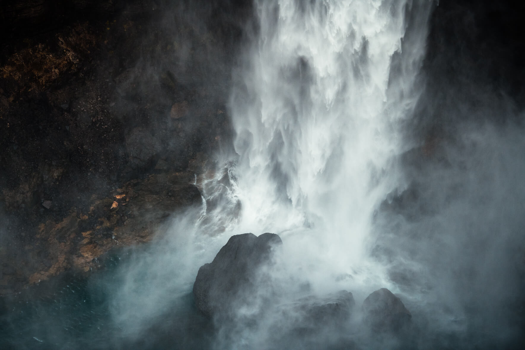 Dramatic photograph of Háifoss waterfall and rocks in the water