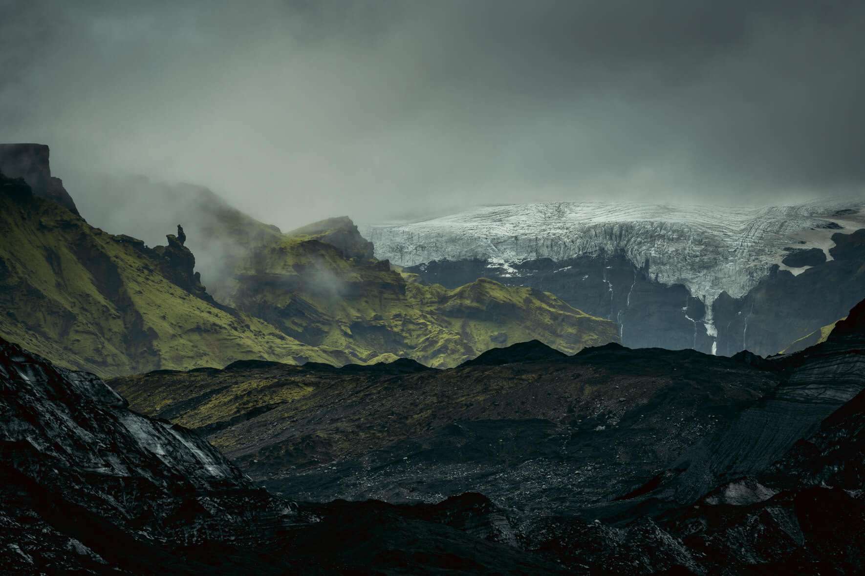 Moody landscape of Iceland with mountains and Mýrdalsjökull glacier in the background