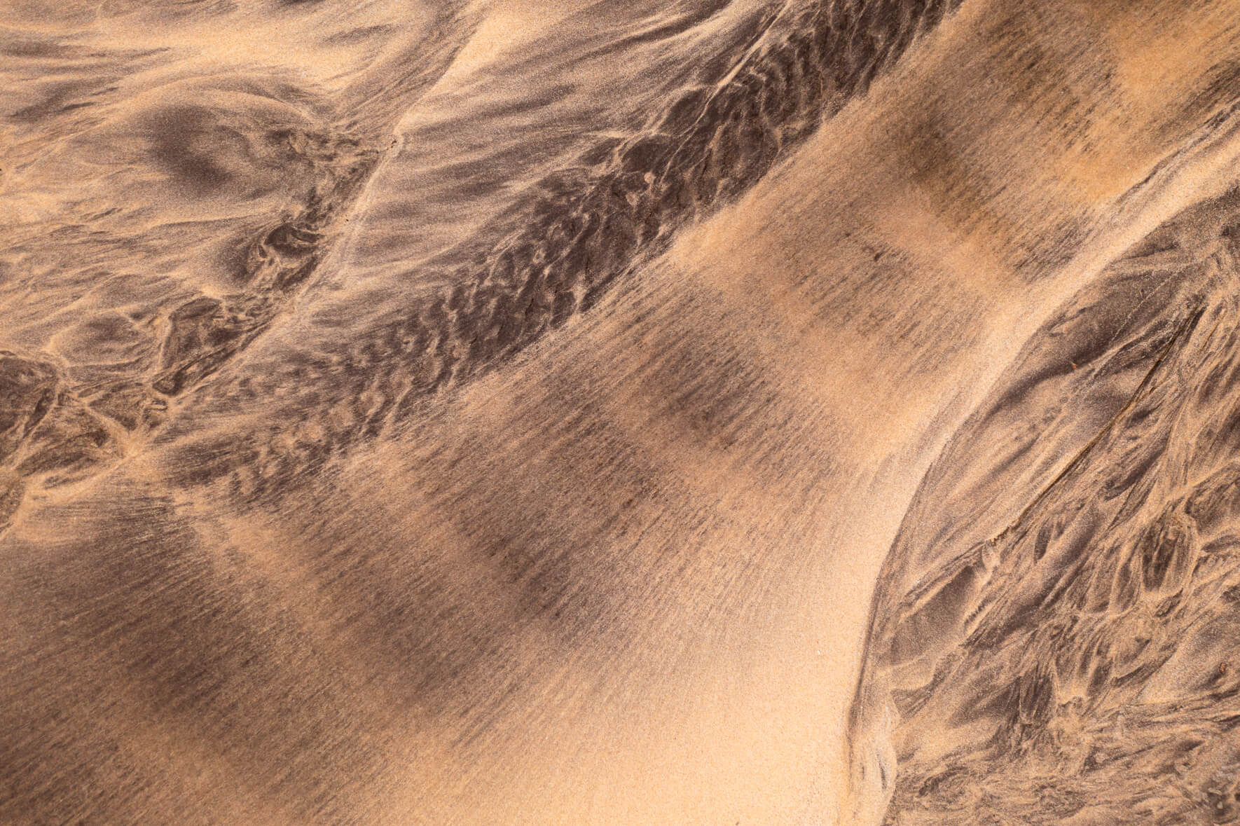 Aerial view of a creek running over a beach in the Westfjords of Iceland
