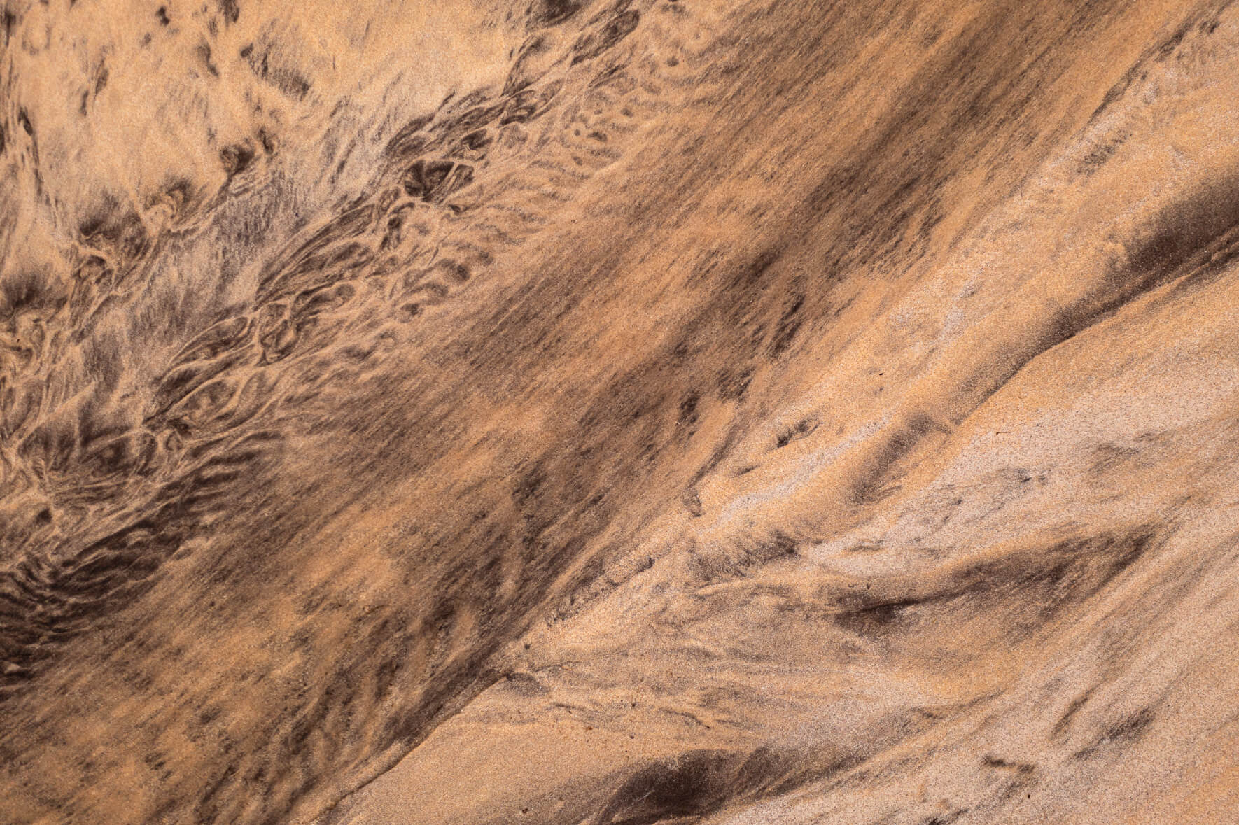 Aerial view of a creek running over the beach into the ocean in the Westfjords of Iceland