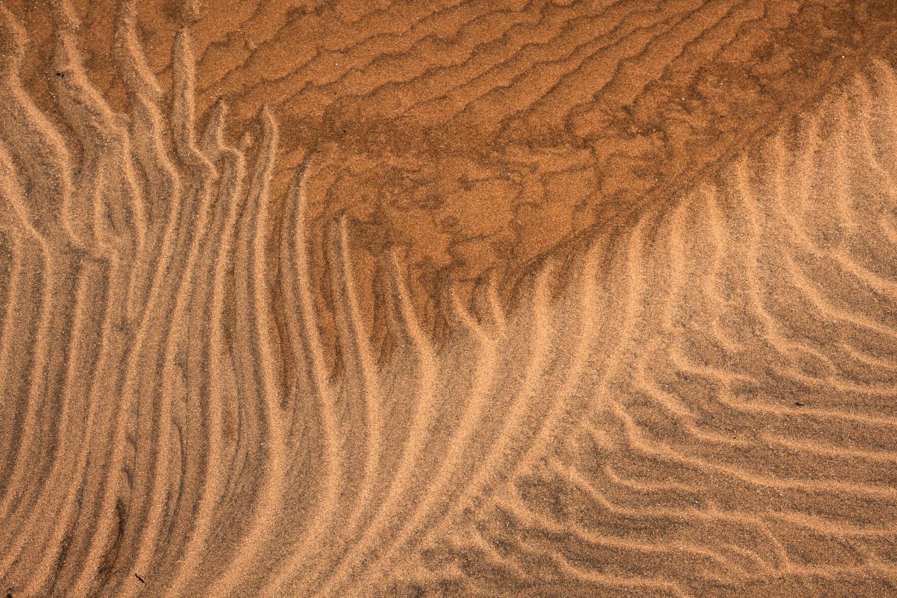 Abstract shapes in sand drawn by sea water in the Westfjords of Iceland