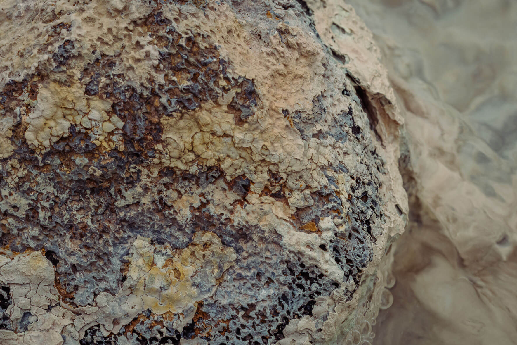 Abstract photography of rocks in a stream bed in a geothermal area in Mývatn region of Iceland