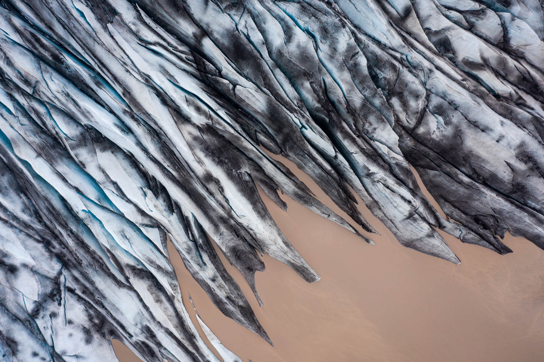 Aerial photograph of a glacier in Iceland with brown surrounding water