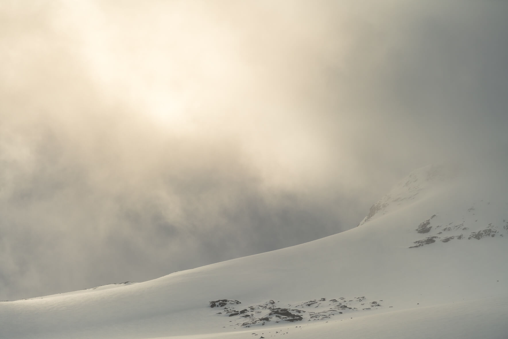 Sun breaks through the clouds over the Sognefjellet mountains and snow-capped peaks in Norway