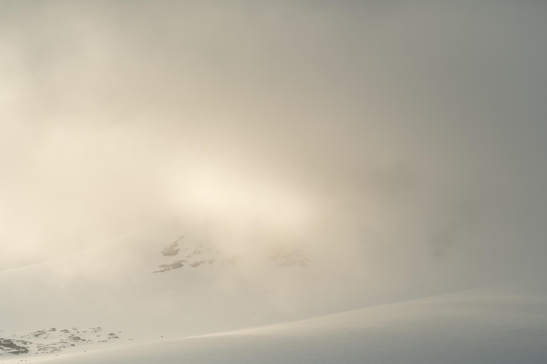 Sun breaks through the clouds over the snow covered Sognefjellet mountains