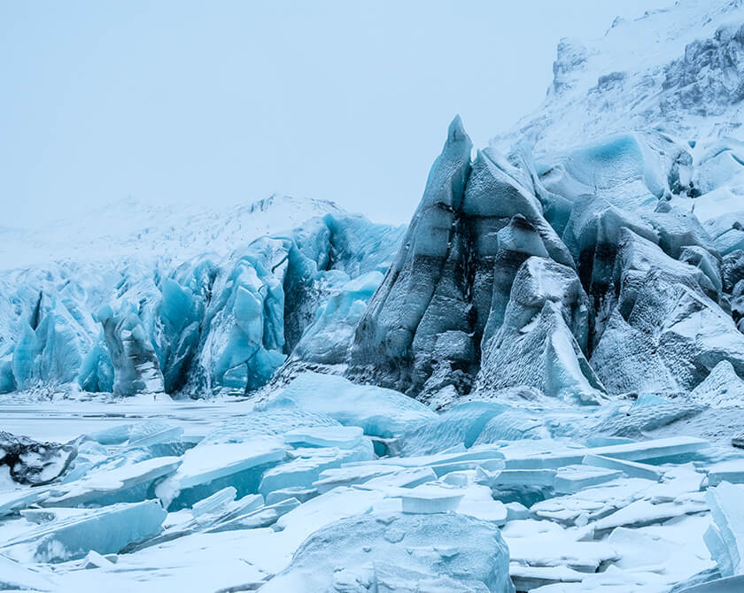 Svínafellsjökull glacier in winter, featuring its blue glacuer ice and surrounding mountains