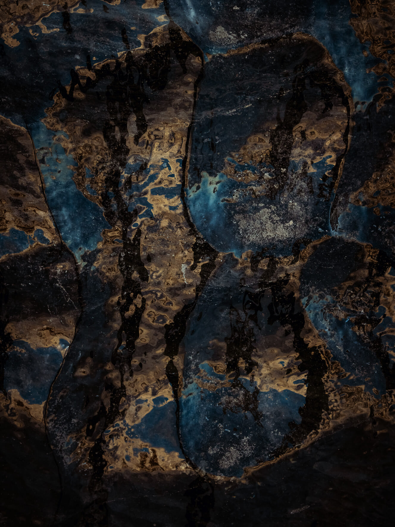 Sunlight reflecting on the dark glacial ice of the Vatnajökull glacier in Iceland creating abstract patterns