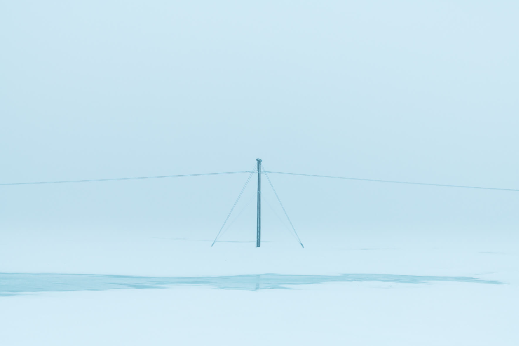 Single power pole in minimalist and snowy winter landscape in Iceland