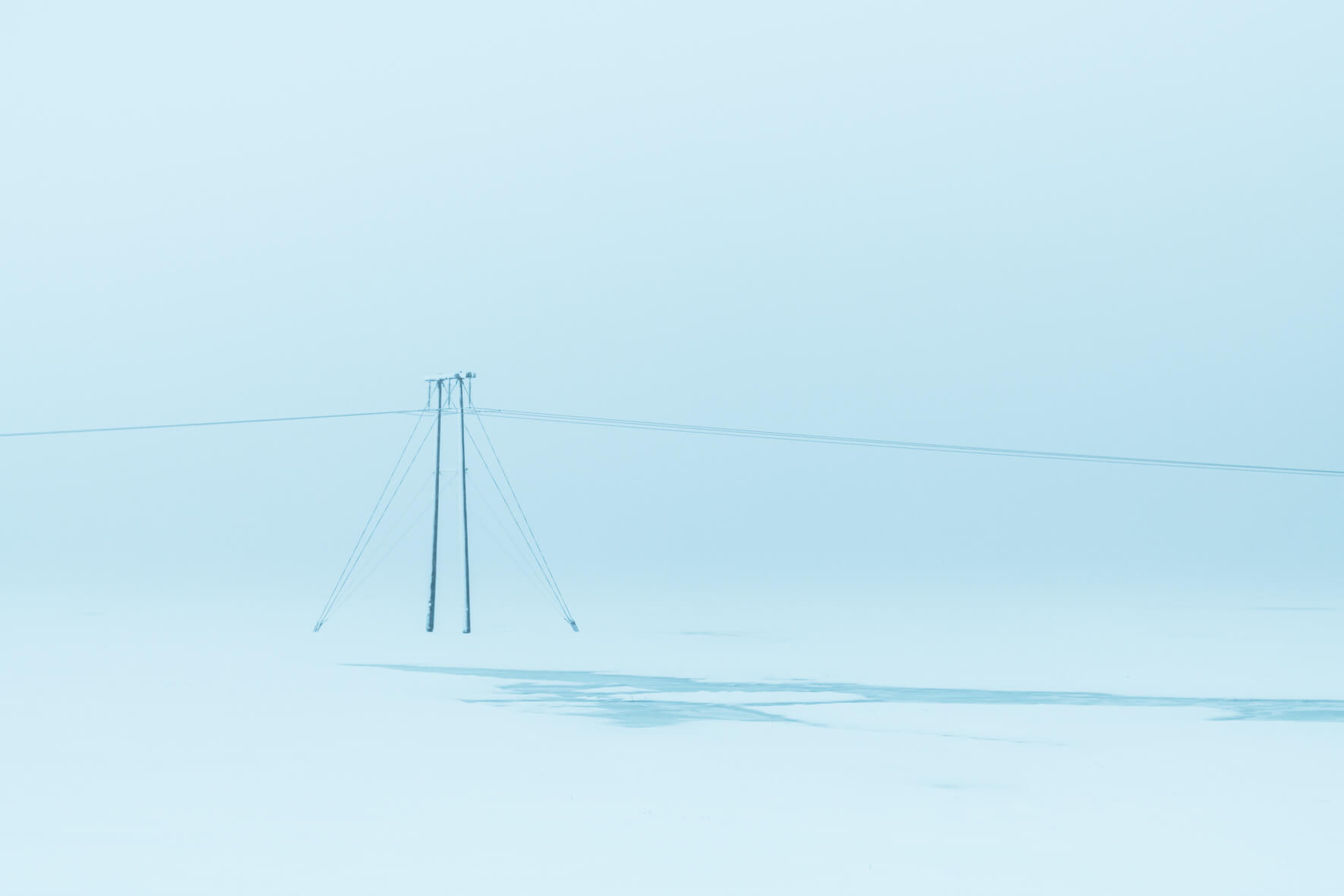 A single power pole in minimalist winter landscape in Iceland with almost whiteout conditions