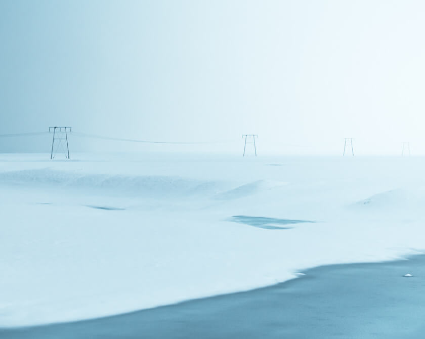 Power poles in peaceful and minimalist winter landscape in Iceland