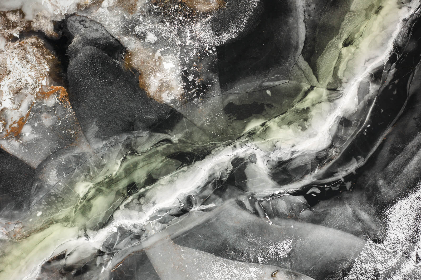 Drone view of a frozen lake in Norway with colorful and abstract textures on the ice surface