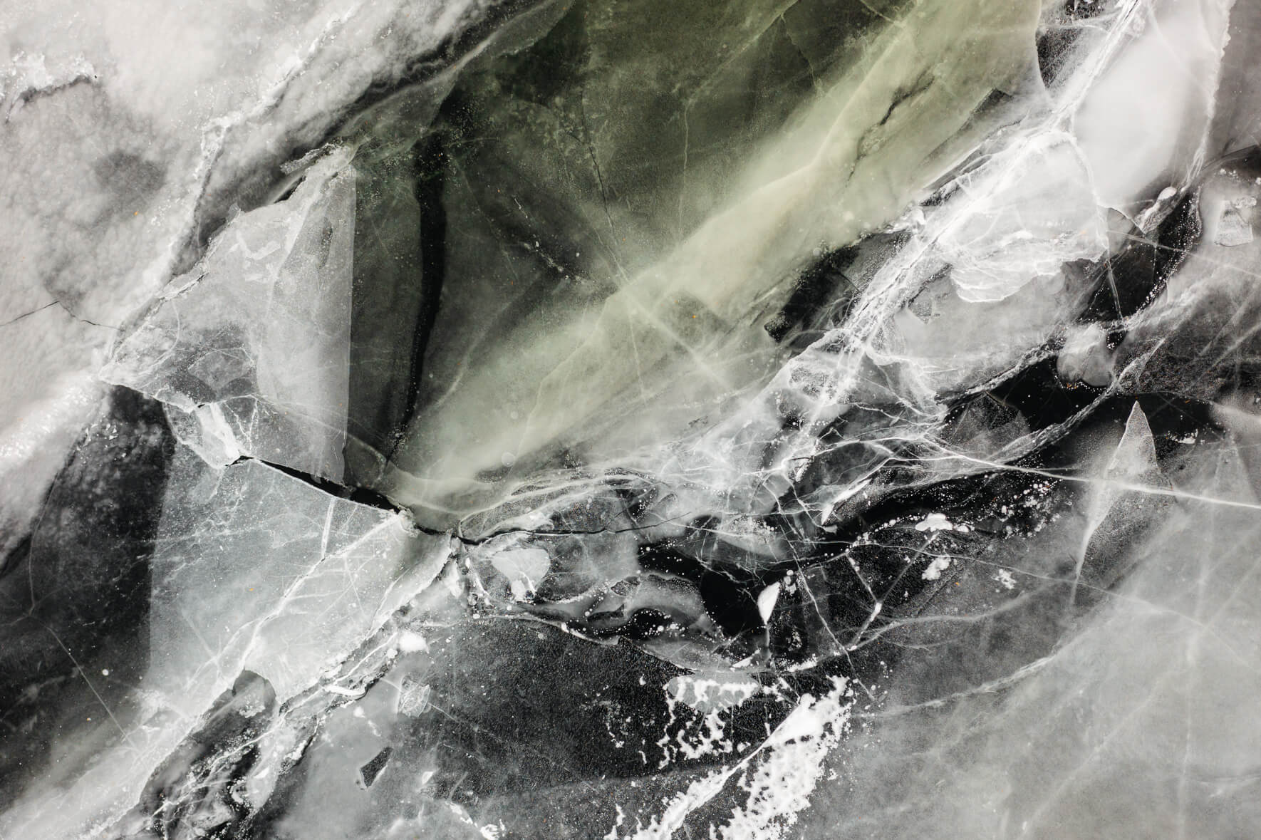 Aerial view of frozen lake in Norway with colorful and abstract textures and breaking ice