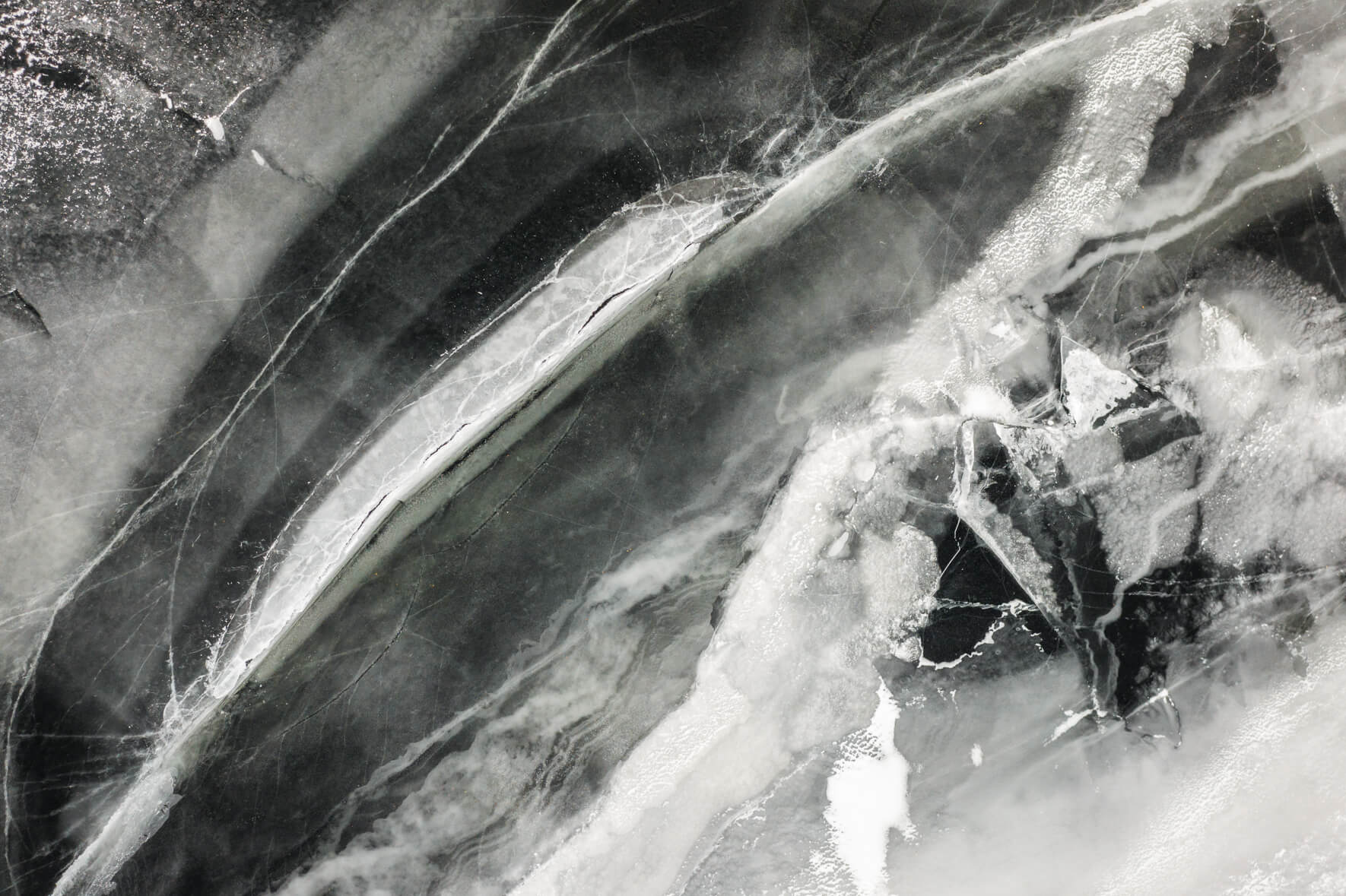 Aerial view of frozen lake in Norway with colorful and abstract textures and patterns