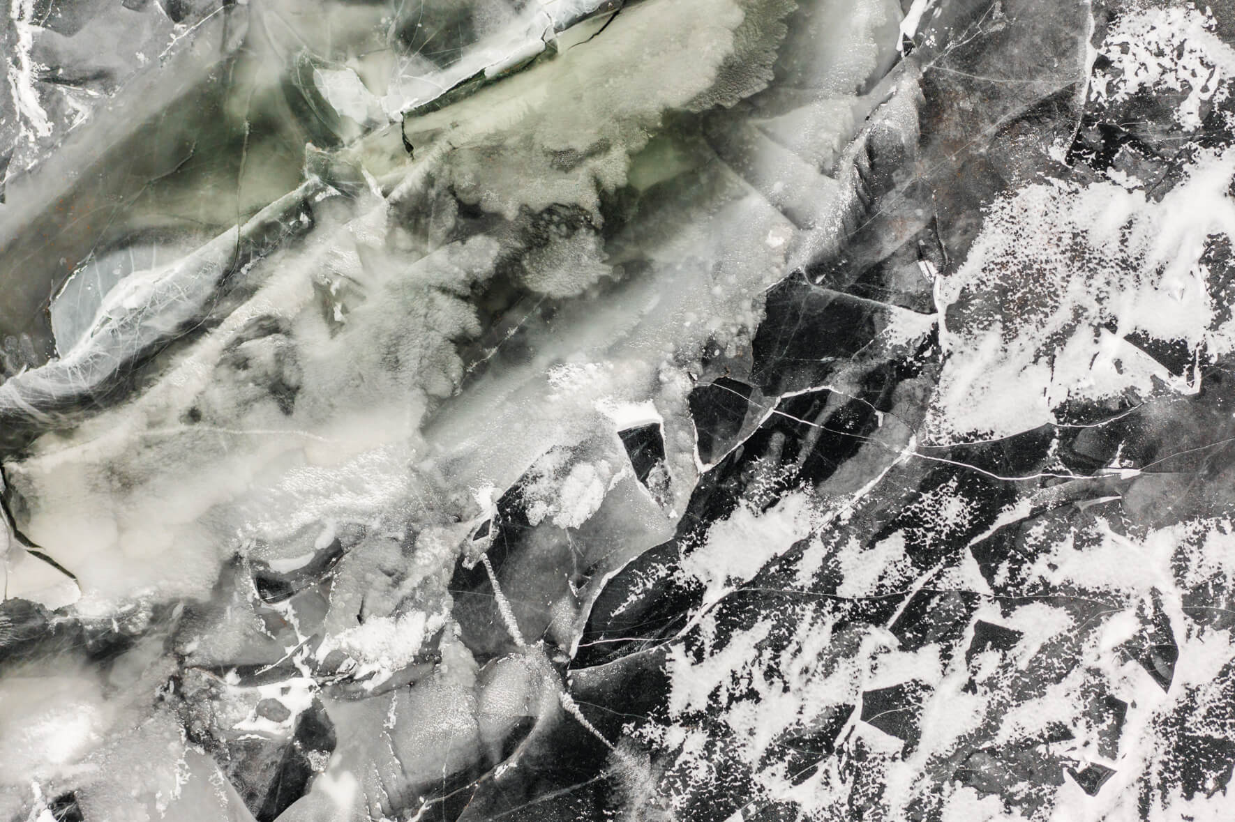 Frozen lake in Norway from with large ice floes and cracks in the ice surface