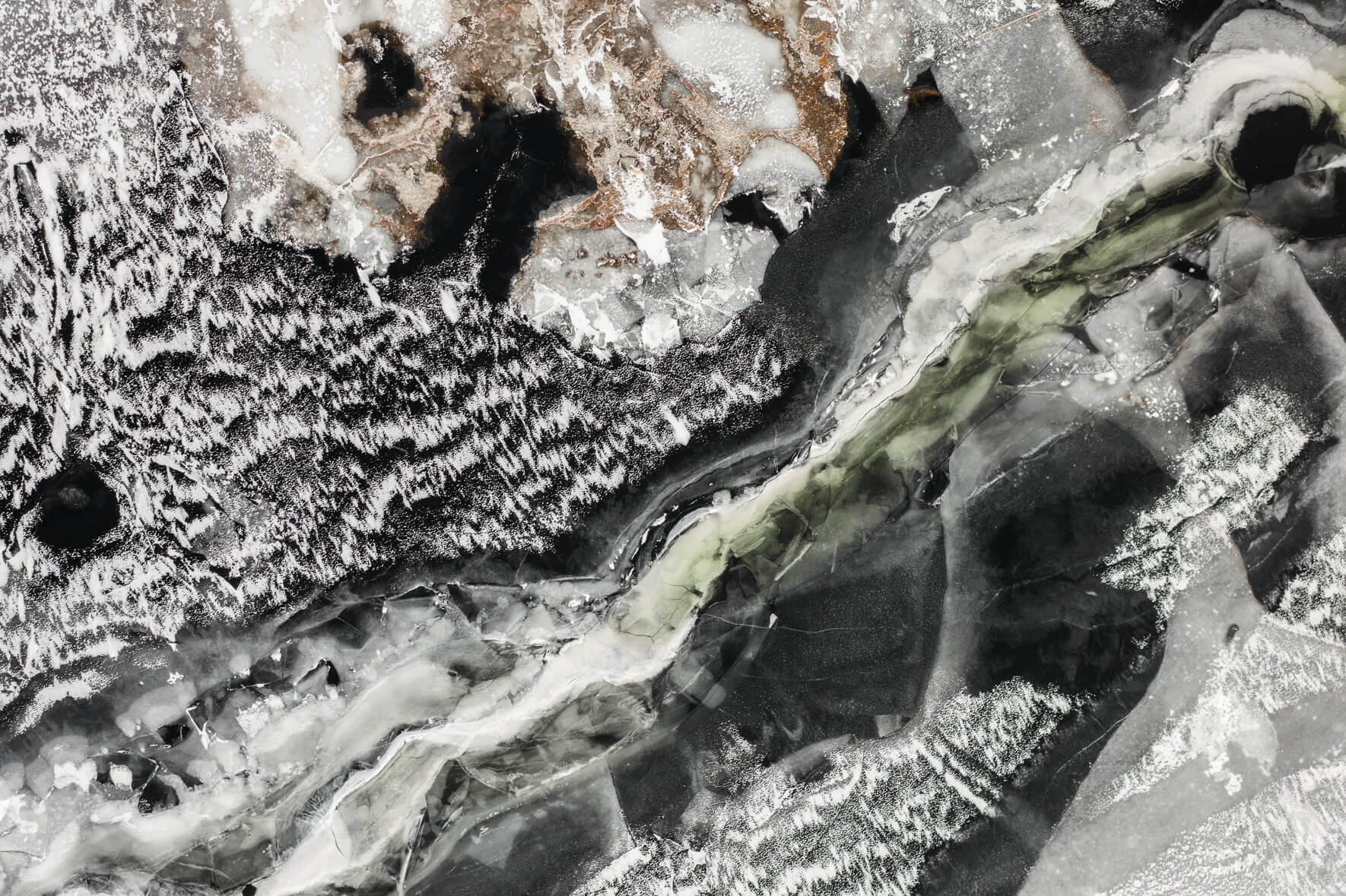 Frozen lake Åraksfjorden in Norway from an aerial view with snow and abstract patterns on the ice surface