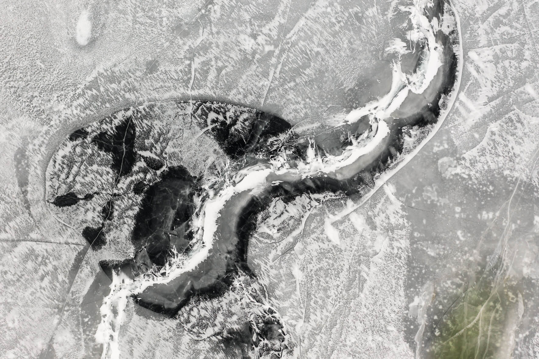 Frozen lake in Norway from an aerial view with snow and abstract patterns on the ice surface