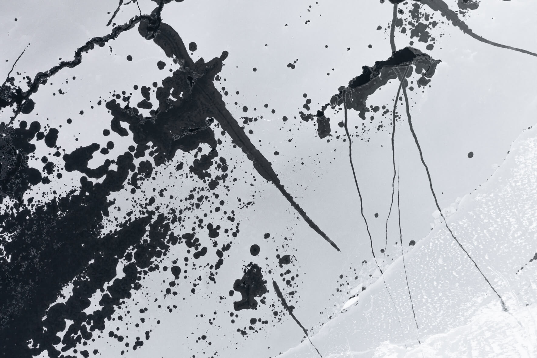 Aerial view of a frozen lake in Norway with hundreds of holes and cracks in ice due to thawing weather