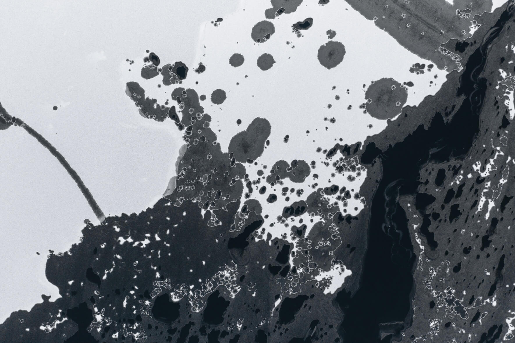 Aerial photo of a frozen lake in Norway with large holes in the ice due to thawing weather