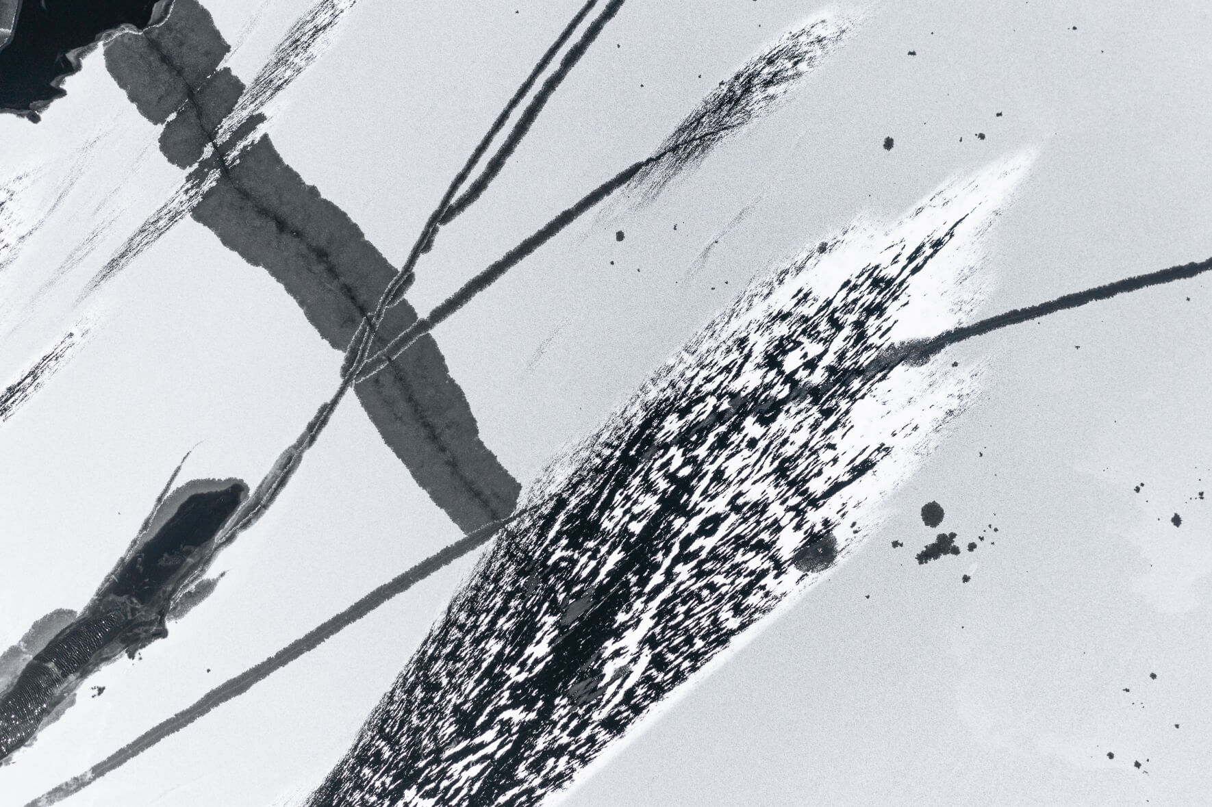 Aerial photograph of a frozen lake in Norway with cracks in the ice due to thawing weather