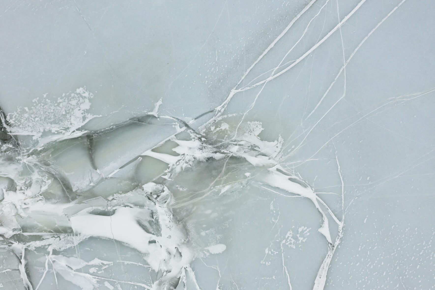 A frozen lake in Norway seen from above cracks and faults in the ice