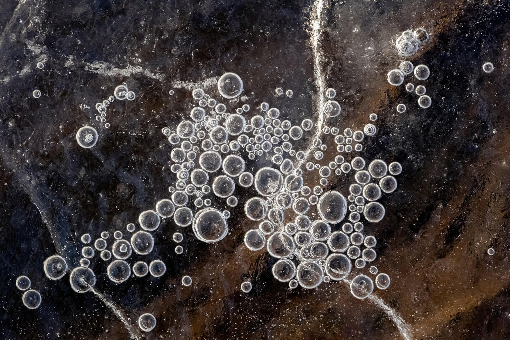 Frozen air bubbles trapped under the ice of a lake in southern Norway
