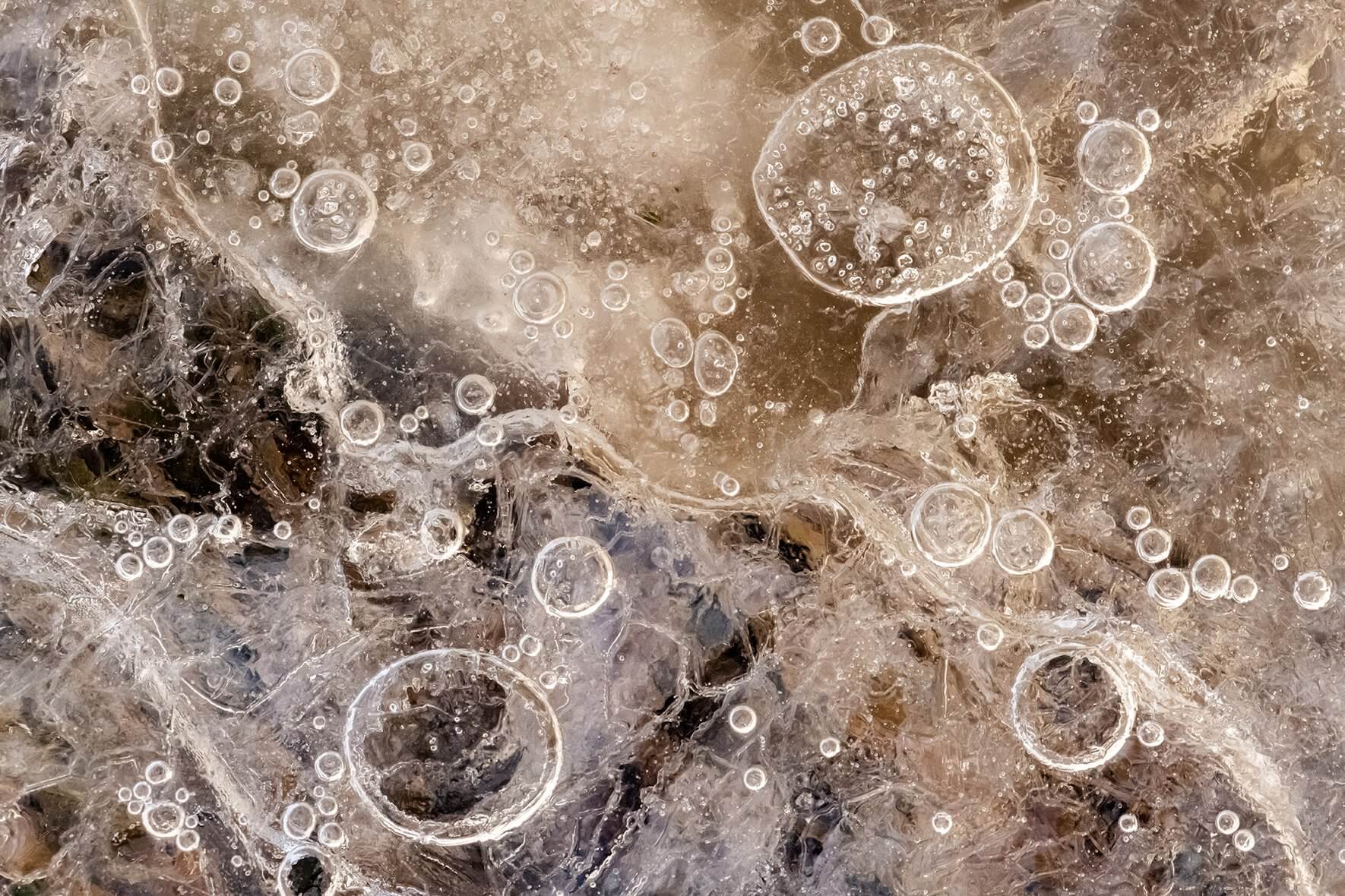 Abstract macro photograph of air bubbles in the ice of a frozen swamp in Norway