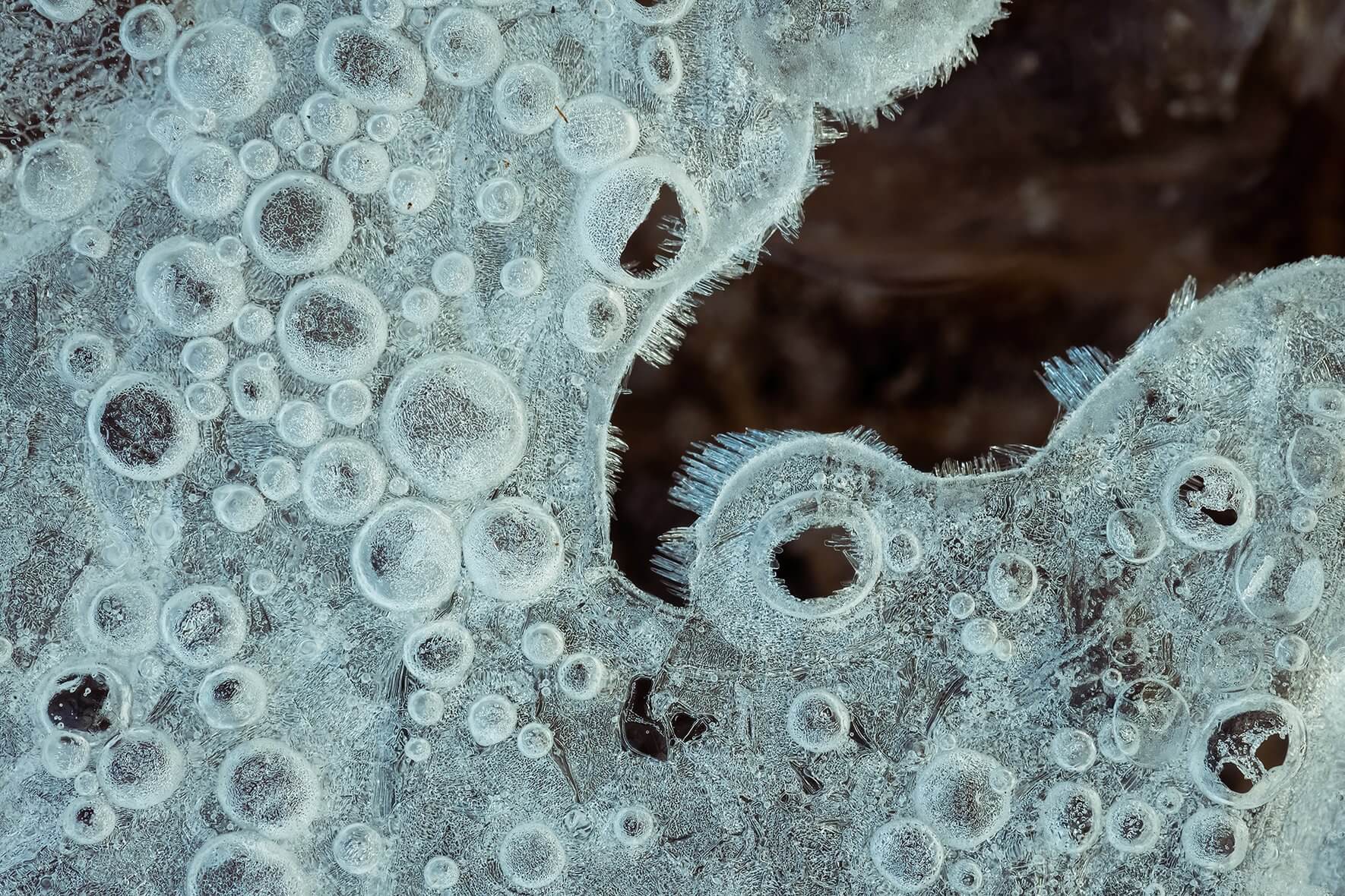 Macro image of abstract air bubbles in the ice of a small creek in Norway