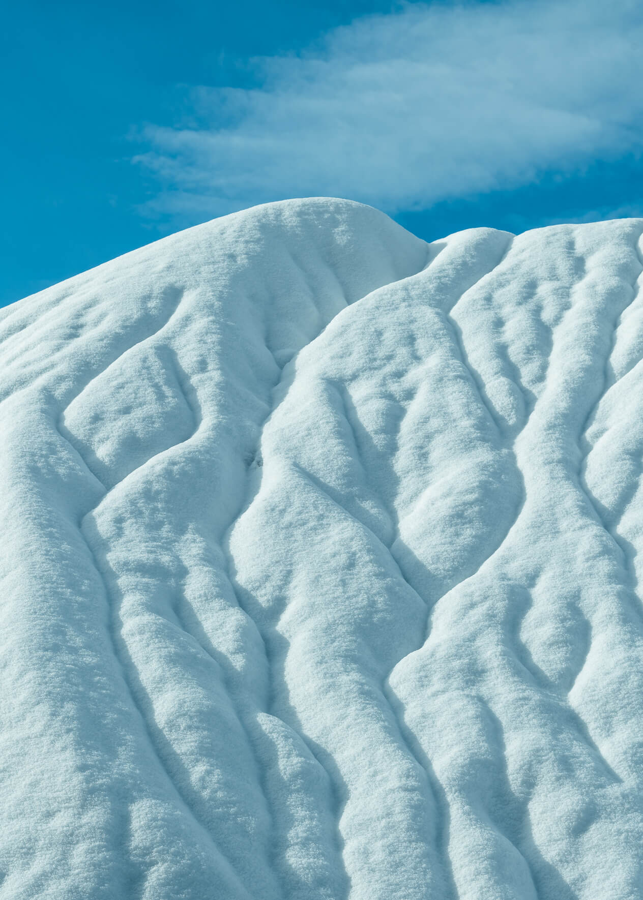 Abstract landscape with snow covered hills and a blue sky