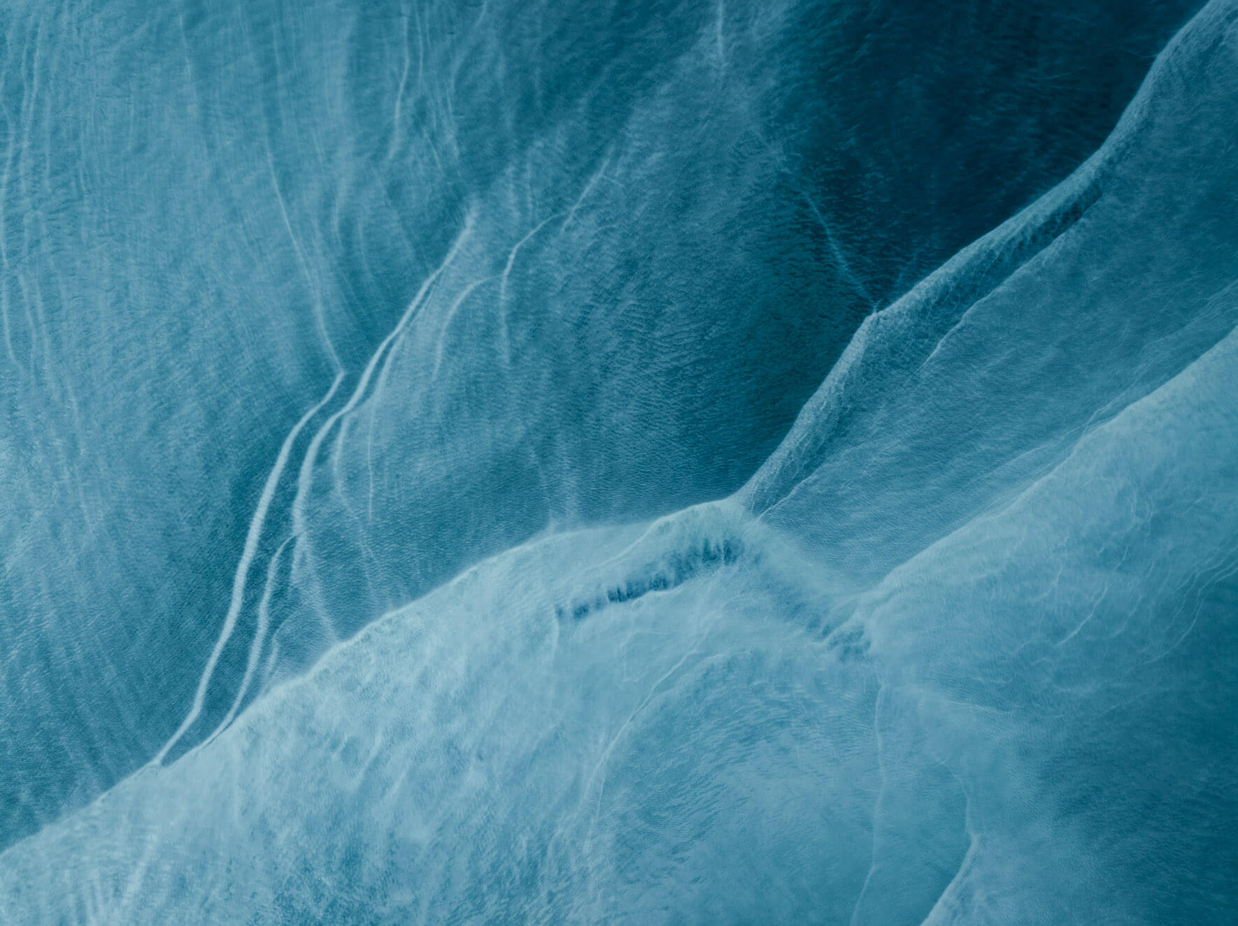 Aerial abstraction of Kachemak Bay in Alaska, where glacial minerals color the sea