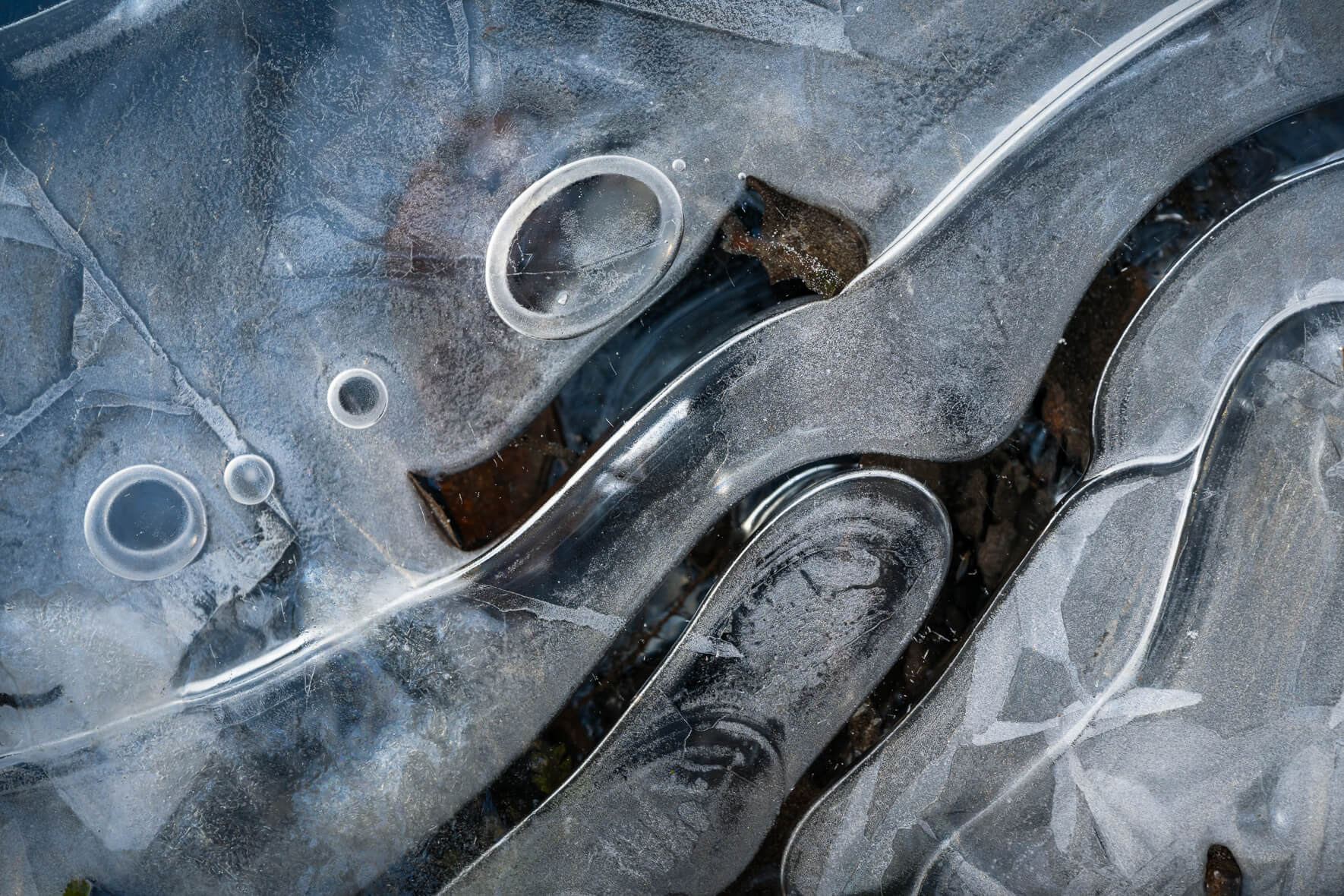 Macro details of a frozen stream with air bubbles