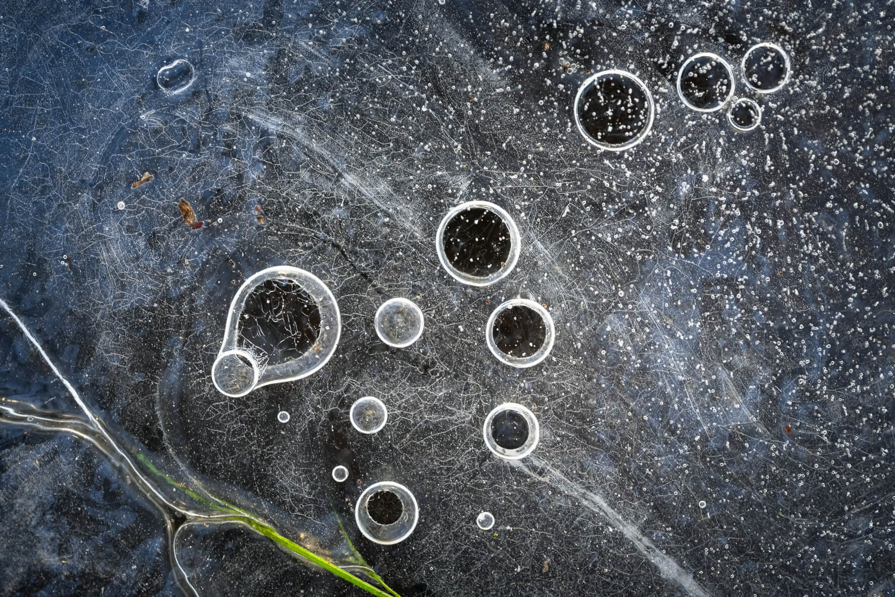 Close-up of a frozen stream featuring macro details and air bubbles