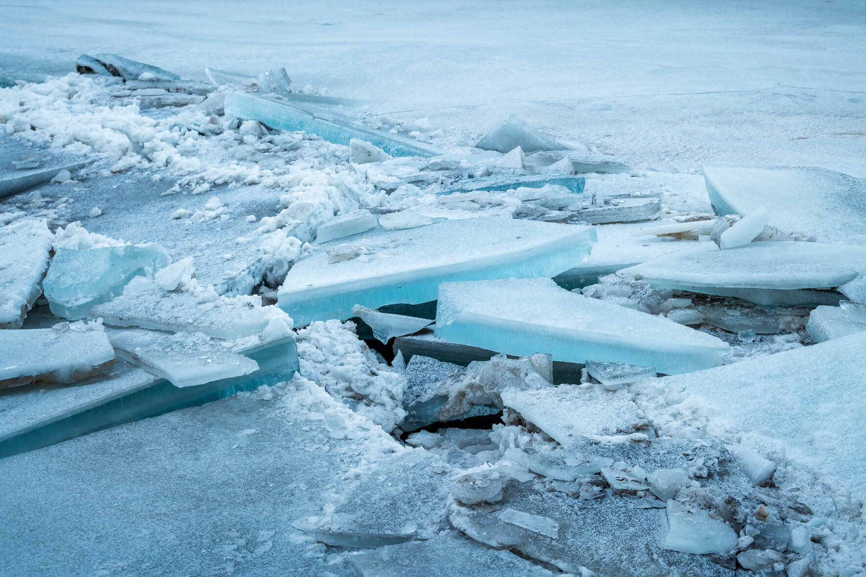 Ice floes on the banks of a river in Iceland with turquoise blue ice