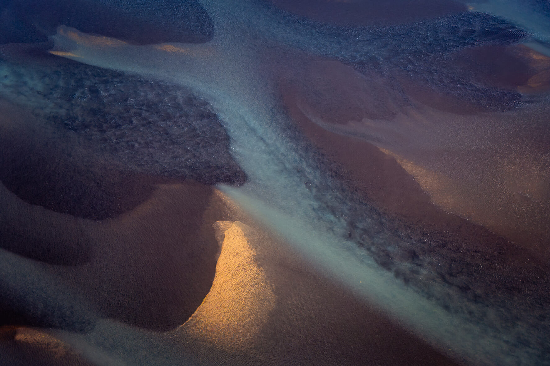 Sediment-laden glacial rivers in Iceland, seen from above, creating abstract patterns