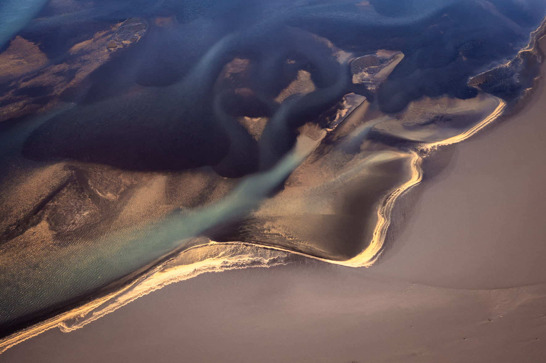 Braided river networks in Iceland, forming intricate pathways as they flow toward the sea